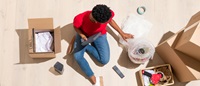 Person sitting on the floor with moving boxes